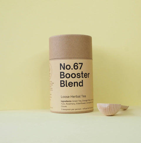 Tub of booster blend with a wooden teaspoon