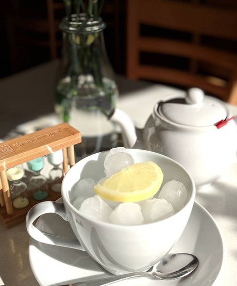 table with cup, teapot ready to pour an iced tea.