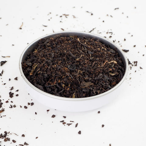Irsih Breakfast tea leaves shown i a white bowland scattered on a white background. Our builders tea, a strong breakfast tea