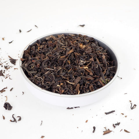 A dish of Darjeeling Loose Leaf Tea, large entangled tea leaves with rich brown tones of off-white to black - this is a premium loose tea from Teaspoon Tea Co