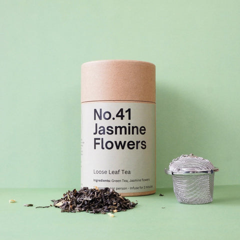 A cylindrical brown container labeled 'No.41 Jasmine Flowers' with text indicating it is loose leaf green tea.