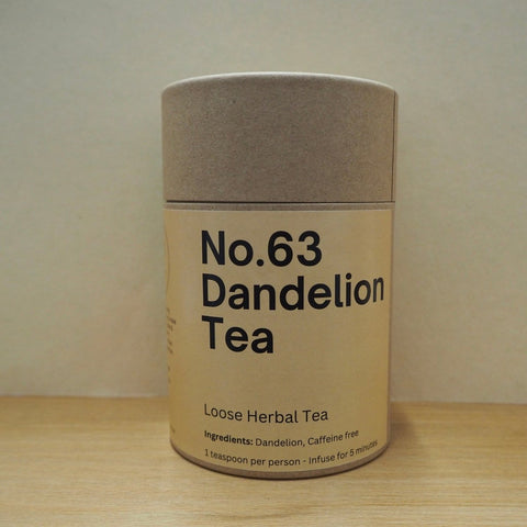 Canister of No.63 Dandelion Tea on a wooden surface with a plain background