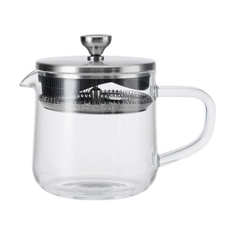 Clear glass teapot with metal lid and handle on a white background