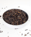 A dish of Darjeeling Loose Leaf Tea, large entangled tea leaves with rich brown tones of off-white to black  - this is a premium loose tea from Teaspoon Tea Co