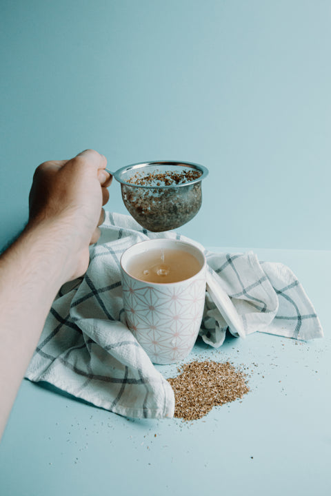 A tea strainers full of loose leaf tea being removed.