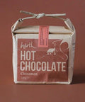 Packaged hot chocolate with a cinnamon flavor on a brown background