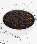Irsih Breakfast tea leaves shown i a white bowland scattered on a white background. Our builders tea, a strong breakfast tea
