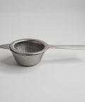 Long handled tea strainer on a white background