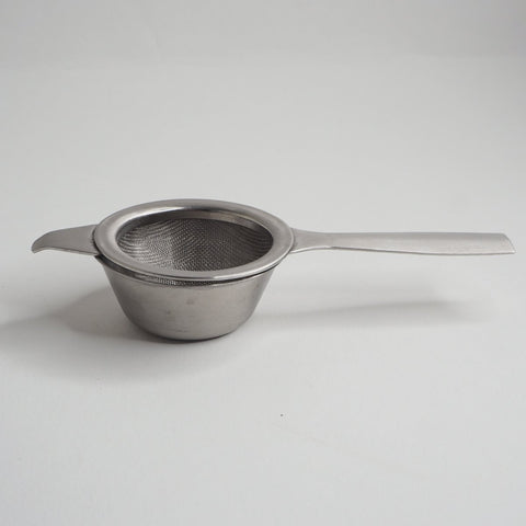 Long handled tea strainer on a white background