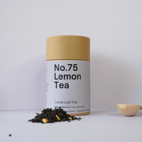A cylindrical paper container labeled 'No.75 Lemon Tea' with loose leaf tea visible in front, on a white background.