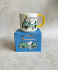 Mug with cartoon design on a box labeled 'Peanuts' on a beige background
