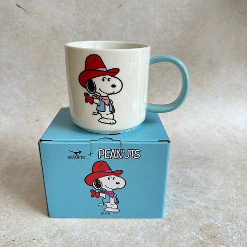 Mug with snoopy on a blue box featuring 'Peanuts' branding.