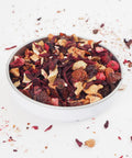 A swallow bowl of Red Berries Fruit tea from Teaspoon Tea Co.  This fruit tea contains no caffeine.  Large red berries and deep red hibiscus leaf can be seen as well as apple pieces.  