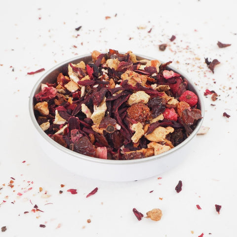 A swallow bowl of Red Berries Fruit tea from Teaspoon Tea Co.  This fruit tea contains no caffeine.  Large red berries and deep red hibiscus leaf can be seen as well as apple pieces.  