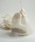 A reusable teabag with tea into and the drawstring pulled