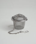 A stainless steel tea basket infuser with a lid and a chain handle