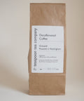 A packet of decaffeinated coffee branded by Teaspoon Tea Co, with a label stating 'Decaffeinated Coffee, Ground, Nottingham'. The packet is brown with a beige label and white text.